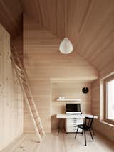 Spruce wood also lines the floor, walls, and ceiling in the bedrooms. The residents must climb a ladder to access the loft above. 