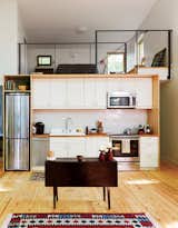 The kitchen and lofted guest bedroom take cues from urban living—including an apartment-size Summit refrigerator. The cabinets are IKEA and the tile is by Heath Ceramics. 