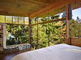 In the sleeping loft, floor-to-ceiling windows overlook the fir canopy of the surrounding forest. 