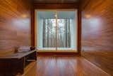 The room is clad entirely in bamboo and frames a view of the surrounding deciduous forest. 