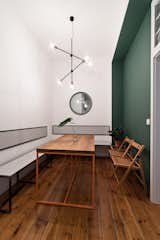 #interior #dining #modern #table #chandelier #benchseating #nowodvorskisticks #pendantlight #minimalist #diningarea #color #accentwall #greenwall #orangesteel #seatbacks 