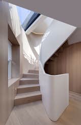 On a triangular site in the Fitzrovia neighborhood of London, architecture firm FORMstudio created an irregularly shaped stair with treads and risers that match the wide-planked, white oak floors. A thick acrylic banister winds alongside the stair like a matte-white ribbon. Together, the white oak and acrylic have a distinctly calm, Scandinavian feel about them.