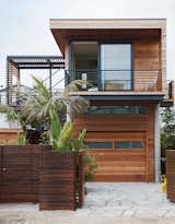 An elevated addition to a 1940s beach house outside of San Francisco rests on piers that catch ocean breezes and allow for views of the Pacific Ocean. Designed by Studio Peek Ancona, the bungalow uses passive heating and cooling, native plants in the landscaping, and an exterior rain screen.