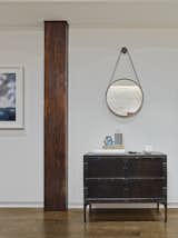 BDDW's Captain's mirror hangs above a Restoration Hardware console. Like the brick walls, the wood column is original to the structure. 590BC kept the surfaces white for a variety of reasons. "It allowed for the richness of the space's natural materials stand out," Breitner says. "The wide-plank oak flooring, exposed brick and metal, and even the view to the SoHo streetscape outside all pop against the white background of the walls. It also allowed the clients to bring in all kinds of artwork and play with color and texture." Photo by Frank Oudeman.