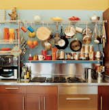 Vintage kettles and a wide-ranging assortment of pots and pans sit above kitchen cabinets from IKEA.