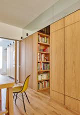 The cabinetry also accommodates a compact library, which can be accessed from the guest room. "The perimeter of the apartment is completely free by concentrating the intervention in one single and continuous volume that works as a spine," the firm explains.