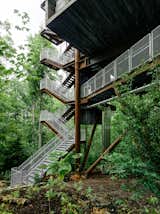 Mithun designed the tree house so that it would tread lightly on the land. The firm originally considered prefabricating the entire structure offsite but, in the research process, concluded that craning large modules into place would potentially harm the canopy. A combination of a bolted-together prefab structure and site-built wood housing yielded the least intrusive construction option. 

The Summit Bechtel Reserve is located in West Virginia's coal mining country. The architects looked to the local structures—bridges, mining apparatus, and other industrial buildings—to inform the tree house's design. A 166-ton Cor-Ten steel megastructure supports the 125-foot-tall building. The use of regionally appropriate materials, like steel and black locust wood, was important to the architects.