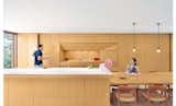 For a Toronto couple with a love of minimalist Japanese architecture, a sleek, storage-packed kitchen was the first priority in their home's renovation. In the kitchen, white oak used for the cabinets, kitchen island, and dining table is finished with double-boiled linseed oil, which can be reapplied by the homeowners as the wood mellows and patinas. The custom beveled edge for the island's "Blizzard" white Caesarstone countertop forgoes the standard one-inch countertop overhang to save on space and maintain a sleek feel. A Vola faucet is used with a sink by Mekal.