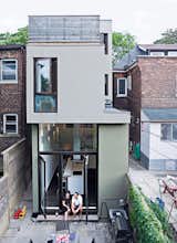 Outdoor, Back Yard, Walkways, Hardscapes, Horizontal Fences, Wall, Wood Fences, Wall, and Stone Patio, Porch, Deck A rear view of the narrow house shows how Chong twisted the house’s volumes to bring daylight into each room.  Photos from Narrow Modernist Three-Story Home in Toronto