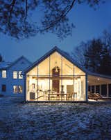 Exterior, House Building Type, Farmhouse Building Type, Gable RoofLine, and Glass Siding Material The Floating Farmhouse’s semitransparent addition has a roofline that matches the pitch of the original 1820s farmhouse. A porch, tucked under the side eaves, is cantilevered over a stream that runs through the property. Ikea loungers are illuminated from the interior by commercial gymnasium lights repurposed as pendant lamps.  Photos from Hope Floats