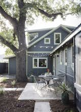 There were numerous design parameters to consider, from adding space to staying within budget to matching the scale of the neighborhood's housing stock, all while remaining as green as possible. (Cue open cell foam insulation at the roof, reclaimed longleaf pine at upstairs bedrooms, metal roof, reclaimed travertine pavers at porch, tankless water heater, 2-speed furnace and condenser, Andersen 100 Series composite low-E windows.) The addition can be seen from the exterior, where Schmeil rotated the roof 90 degrees so the gable faces the street, and stepped the second floor back at a dormer that brings light into the upstairs bathroom and music room. Photo by Whit Preston.  Photo 5 of 5 in Smart Renovations That Use Reclaimed Materials by Luke Hopping from Family-Sized Addition for Renovated Austin Bungalow