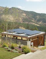 The Solar Revolution installed 3.6-kilowatt photovoltaic solar panels on top of the carport, which sports a board-formed concrete exterior and a cedar-slat-and-plywood interior.