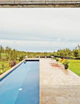 The pool juts out perpendicularly from the main house; the land was bulldozed to become level with the concrete pavers.