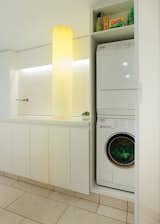 The focal point of the sleek, white space is a glowing laundry chute illuminated from within by fiber-optic cables.