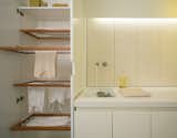 The cabinetry cleverly conceals everything, including a custom drying rack.  Photo 3 of 4 in Laundry Room by Nadia P-C from A Bright Modern Laundry Room We'd Actually Like to Spend Time In