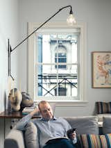 In the loft’s living area, Marcovitz sits on a Charles sofa by Antonio Citterio for B&B Italia, in front of a Jean Prouvé Potence Lamp that has been reissued through Vitra.  Photo 13 of 13 in Lights by Michael R. Savarie from NYC Home Renovations