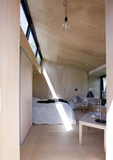 In Præstø, on the Danish island of Zealand, a guesthouse infuses the regional vernacular with Japanese influence. The interior is small, but comfortable. It fits a double bed, coffee table, and chair. The bed is recessed into the wall so as not to waste any space. Natural light floods the interior from a clerestory.