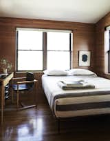 The rooms, featuring sloped ceilings, feel small and intimate. In the guest bedroom, there is a custom bed and a Swedish school desk found on eBay.