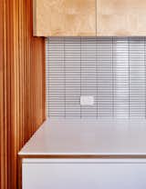 A wall of three-inch-wide cedar slats contrasts with the tile backsplash.