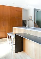 Kitchen, Wood Cabinet, Light Hardwood Floor, Recessed Lighting, and Undermount Sink The dining table narrows to a counter attached to the island.  Search “Counter-Arguments.html” from A Completely Dysfunctional Nevada Kitchen Becomes Everyone’s Favorite Spot for Parties