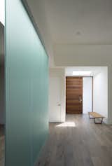A frosted-glass partition separates the living spaces.
