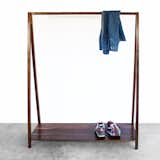 The Walnut Coat Rack takes a simple household accent and elevates it with rich walnut wood. Featuring a trestle shape, the coat rack includes a base on which to rest shoes and boots, and a connecting bar that can be used to hold hangers or drape scarves and jackets. The result is a balanced piece that is geometric and refined.