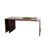 The Extending Desk is an innovative home furnishing that can be used as both a desk and dining table. The walnut table can expand from five feet to ten feet, making it easy to adapt from a casual four-person meal to a dinner party with eight guests. While most extending dining tables require removing and storing a table leaf, this table expands simply by sliding.