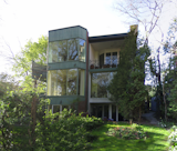 A view of the home's rear facade, prior to the renovation and extensive landscaping updates, featured paneled windows and a darker palette.  Search “Coolest-Homes-for-Artists--Art-Collectors.html” from Inspired by an Art Piece, a Collector Renovates His Toronto Home