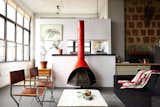 "I’m not trying to hide anything. I wanted to stay true to the industrial look," explains Owen Wright, the owner of this Brooklyn loft. Owen works with his building’s landlord and consequently has accrued countless pieces of furniture from both former tenants and Craigslist—including this 1960’s bright orange metal fireplace and pair of steel frame chairs Owen had reupholstered. A BoConcept sofa and coffee table Owen constructed himself complete the living room.