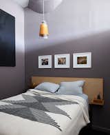 Woodworking is another of Owen's hobbies and his bedroom features a bed and closet he designed and built himself. A blanket from Joinery complements the wood grain of the custom headboard. The pendant light was a flea market find.