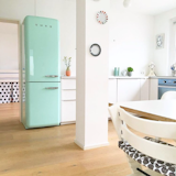 @solebich shared this photo of a bright kitchen-dining area with a turquoise Smeg refrigerator.