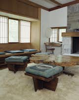 The living room in Nakashima's Reception House features several Greenrock ottomans and a Buckeye burl coffee table. The complex also includes a pool, arched pool house, workshop barn, and studio, among other structures.