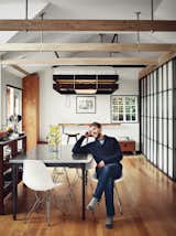 Here, homeowner Vincent Kartheiser is seated in his kitchen. Behind him, you can see the bed raised to the ceiling and the huge slab of redwood that served as a headboard, is now flipped down to create a bar-height desk. Making key elements to double duty, such as the head board/desk, are trademark qualities of small spaces done right.&nbsp;