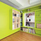 Yuko Shibata, a Tokyo architect, wanted more shelf space in her home office, so she added a plywood door with built-in bookshelves that opens into her bedroom to form a reading nook. Glimpsed from the adjacent room, the space looks larger than it actually is, thanks to the bright green walls. Photo by Ryohei Hamada.