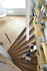 Staircase, Wood Tread, and Metal Railing Ran and her brother, Gen, read on one of the structure’s 44 continuous steps.  Photo 1 of 3 in This Sculptural Staircase Shapes an Entire Home