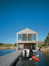 Exterior, House Building Type, Boathouse Building Type, and Wood Siding Material Cedar slats help this Ontario lake house float soundly atop still waters. Photo by: Raimund Koch  Photo 4 of 9 in Modern Floating Homes and Houseboats by Andrea Smith from From Floating Homes to Prefab Moss-Covered Theaters, This Firm's Monograph Has It All
