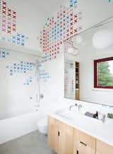 Husband-and-wife ceramic artists, Dear Human, baked x-shaped decals into store-bought Olympia Tile before arranging them in the kids’ bathroom. The tub is by Bette and the sink, set in a Corian countertop, is by Duravit.