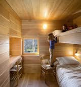 The kids' room is wrapped in wood and features built-in bunk beds for a relaxed and cozy camp vibe. It's outfitted with built-in bunk beds.