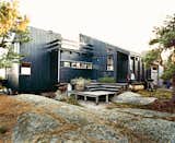 Exterior, Cabin Building Type, Wood Siding Material, and Shed RoofLine Blocked from the wind, a deck at the rear of the house is a favorite place for sunbathing and also shelters planters of herbs.  Search “wind” from Norwegian Wood