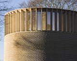 Clerestory windows, set into the brick facade with fins, rings the top of Níall McLaughlin Architects's chapel at Ripon Theological College in Oxford.