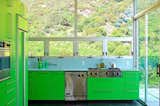 The surrounding, rolling landscape of this Malibu home influenced designer Bruce Bolander’s use of green on the cabinets and appliances in this kitchen.