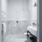 Light gray stone and stainless steel fixtures make up the palette of this clean bathroom.