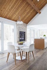New skylights and a wall of windows fill the open-plan area with light. A two-way indoor/outdoor stone fireplace enhances the home's connection to nature.