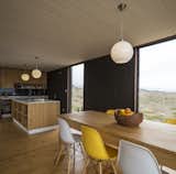 Eames DSW Molded Fiberglass chairs surround the dining table made of local wood and constructed by the owners.