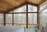 From the northeast corner of the master bedroom, the homeowners can walk out onto a deck area to enjoy the view of the woods.  Photo 7 of 7 in After a Fire, a Midcentury Home Rises from the Ashes