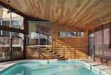 One of the biggest challenges of designing around an indoor pool was managing the humidity, especially with a sloping Douglas fir ceiling. Moser explains that by using a retractable pool cover it helps manage humidity levels. While in the winter there is low humidity, a little actually prevents the wood from drying out.  Photo 5 of 7 in After a Fire, a Midcentury Home Rises from the Ashes