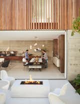 With the home’s glass walls pulled open, the patio becomes an extension of the dining room. A trio of Panton chairs surround a fire pit should guests choose to congregate outside.