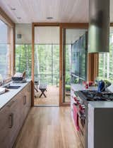In the kitchen, the cabinetry is walnut veneer with a weathered finish applied by cabinetmaker David Rogers. “The process involved sanding and rubbing in stain as well as adding a clear finish,” project architect Eero Puurunen says.