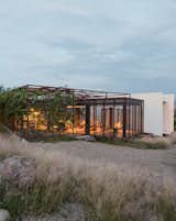 Two art studios adjoin a central volume at this work/live residence built from terracreto (sustainable concrete), glass, and painted steel just outside of San Miguel de Allende, Mexico. Residents Austin and Lida Lowrey, retired design and museum professionals, collaborated with their two daughters—Sheridan, an artist, and Elizabeth, an architect—to design the structure as a place for creative contemplation.