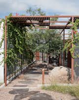 Outdoor, Walkways, and Back Yard Outside, a gridded trellis with sheet-punched panels overlays the structure and extends into the landscape, providing shade in the warm desert climate.  Photo 8 of 12 in 6 Lessons We Can Learn From Traditional Mediterranean Building Techniques from These Separate Studios Keep a Retired Couple Happy